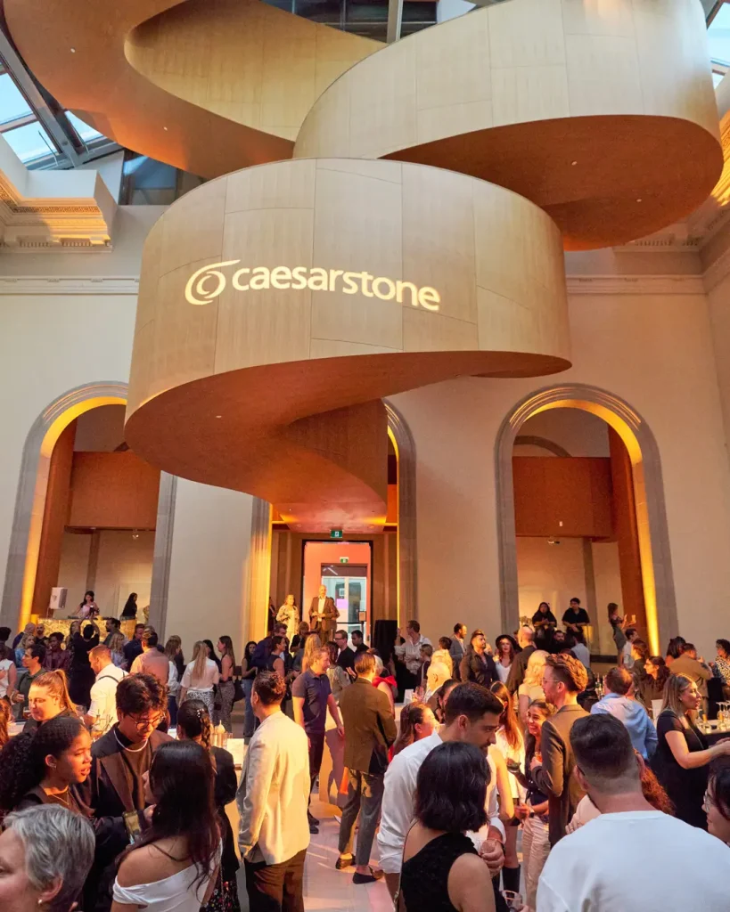 Guests gathering under a custom wooden spiral installation at a Caesarstone event designed by Level Studio, hosted at the Art Gallery of Ontario (AGO) in Toronto.