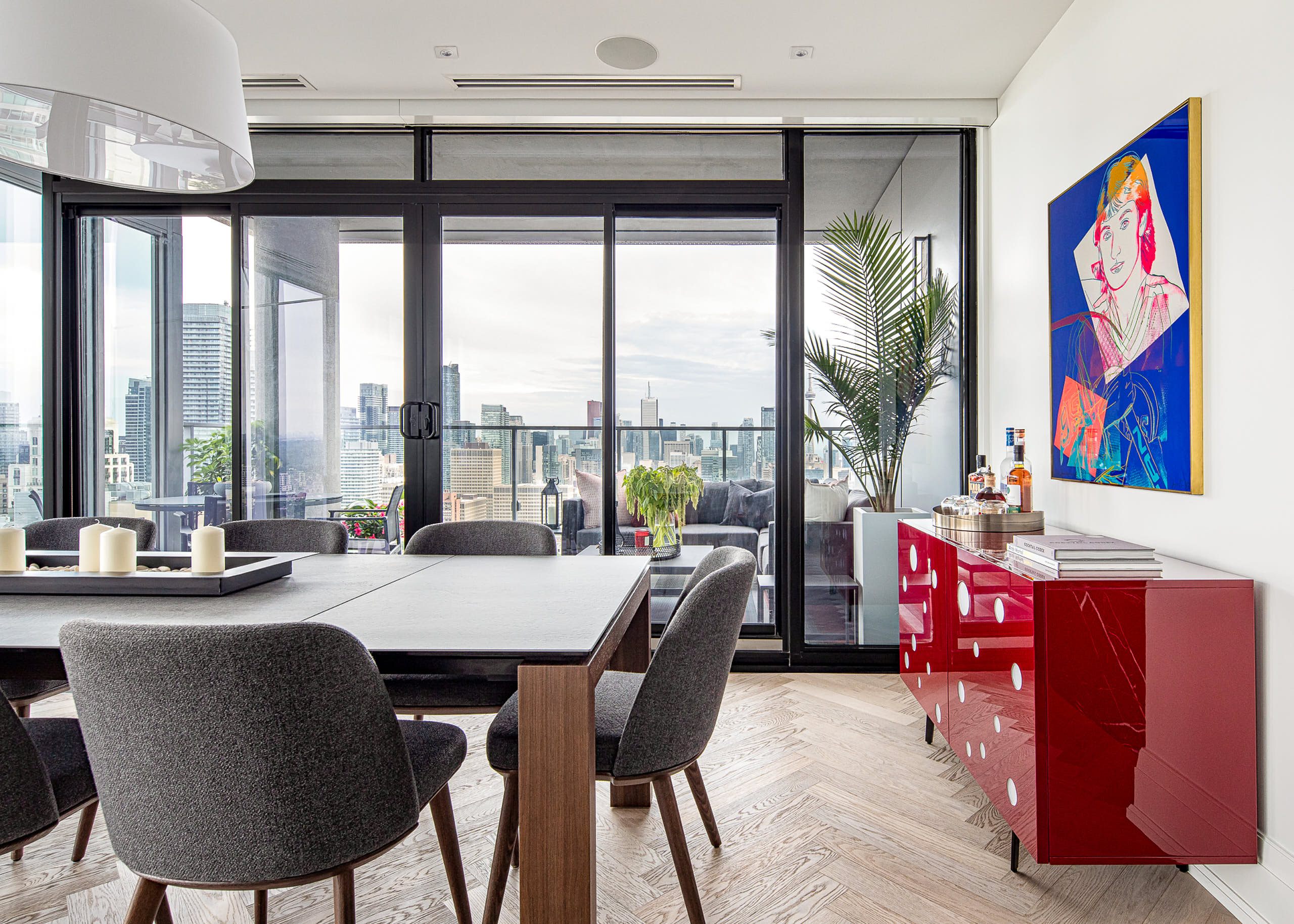 Front view of the Yorkville dining table and signed Warhol print with the Toronto skyline in the background.