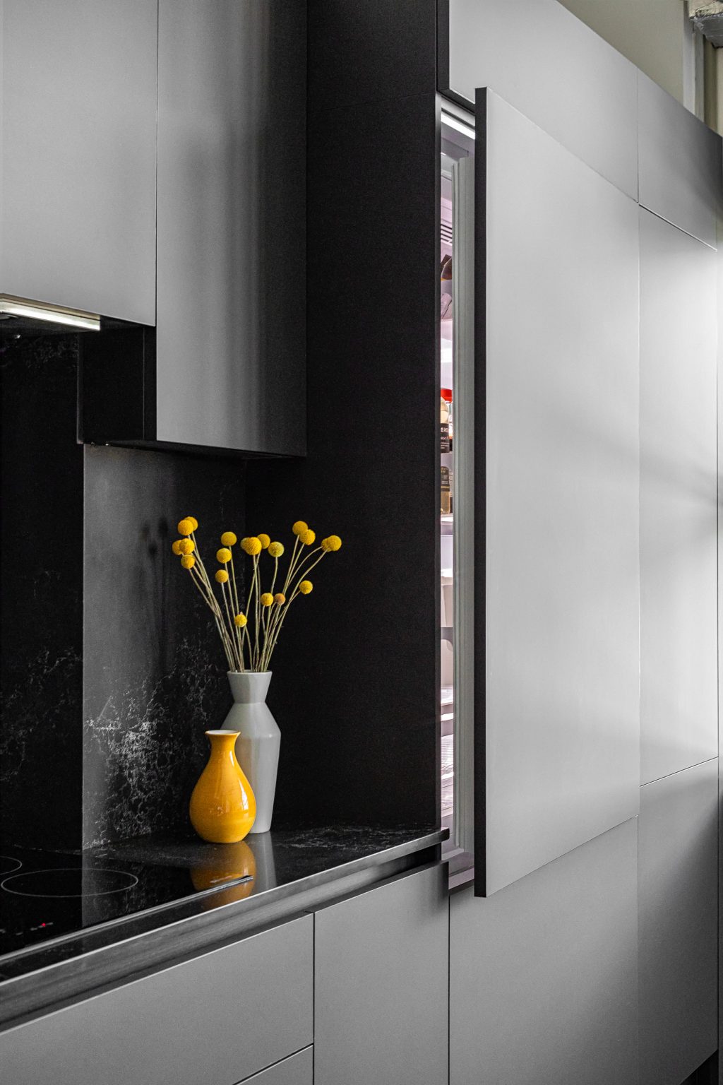 Panel ready refrigerator integrated into dark kitchen cabinetry