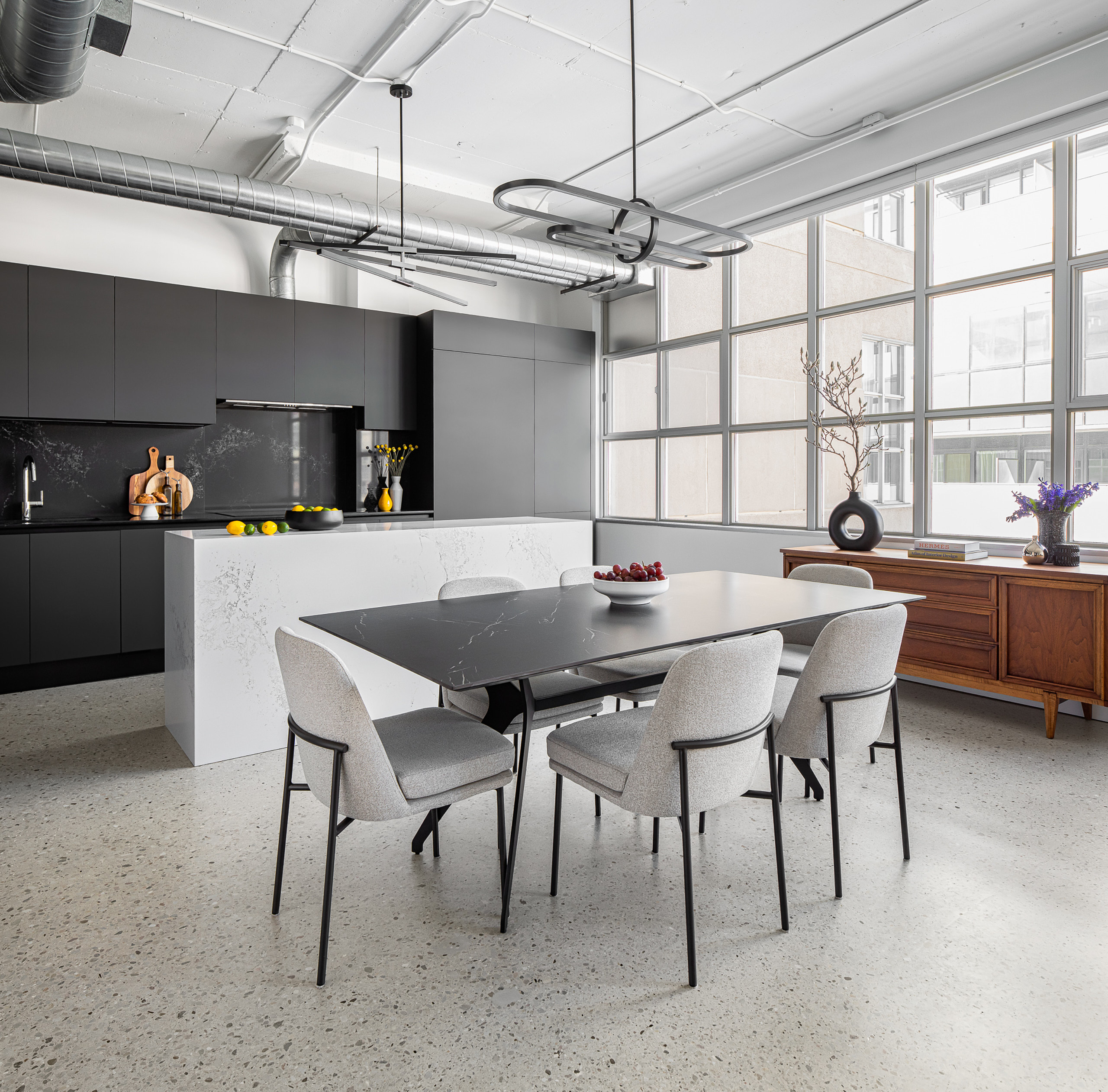 Open concept dining area adjacent to kitchen in industrial loft