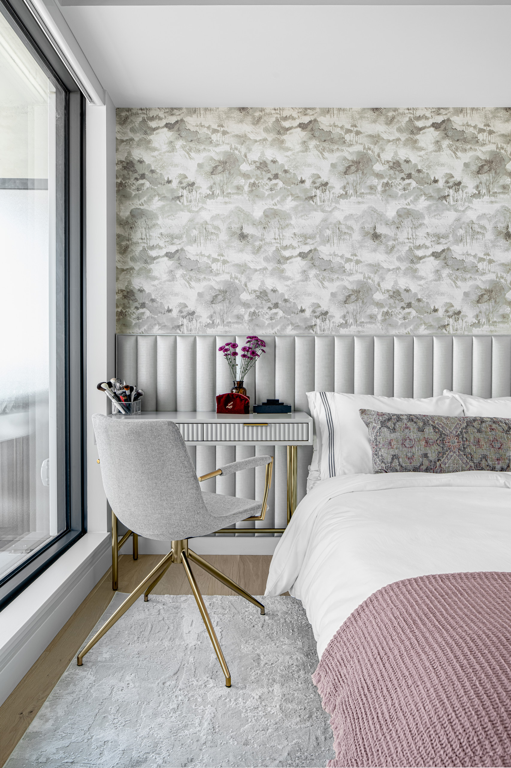 Grey makeup vanity and chair with gold legs set against a grey fluted wall and landscape wallpaper