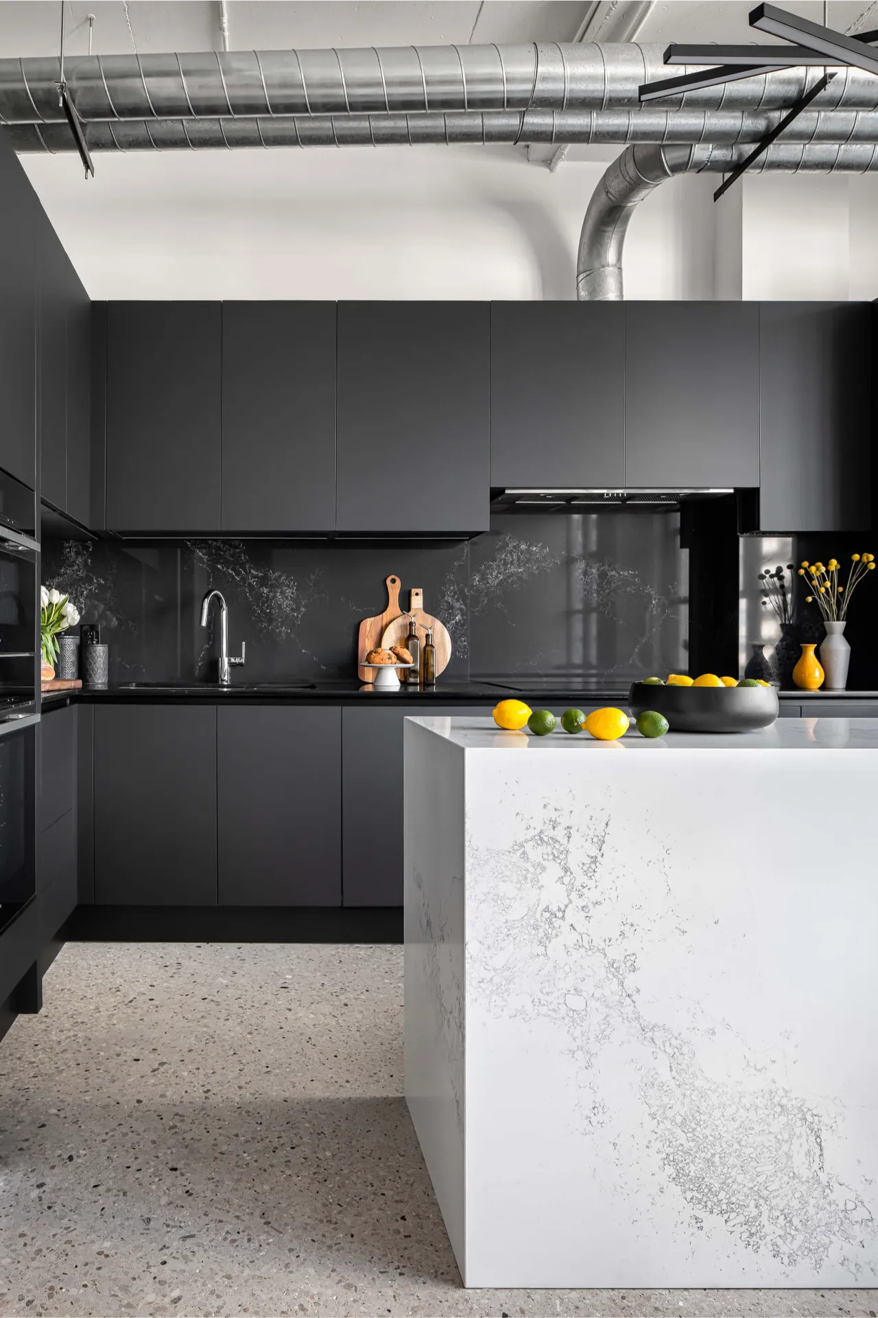 Black and white kitchen with matte cabinetry and marble island in Eglinton loft