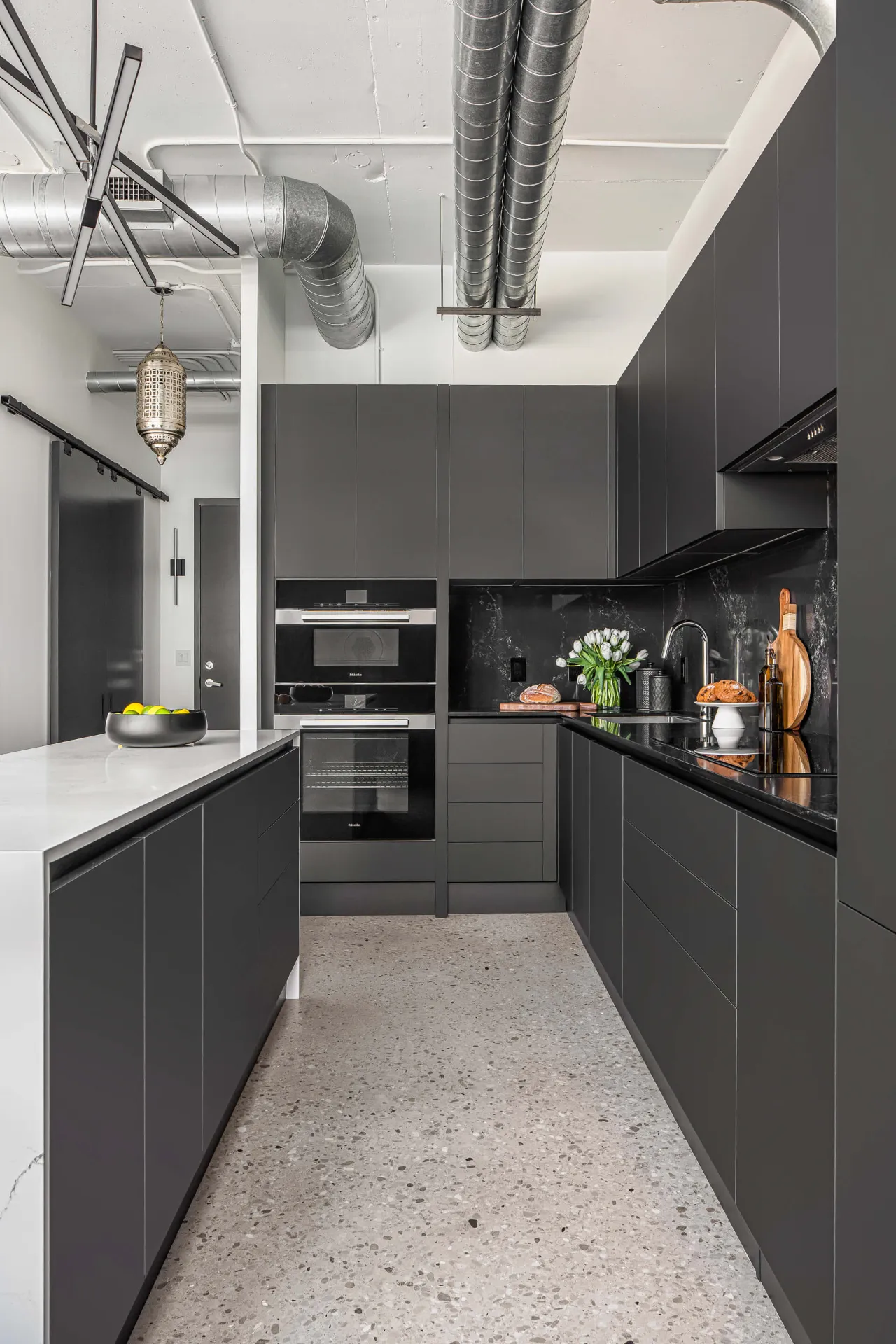 Galley style kitchen layout with dark cabinetry on both sides