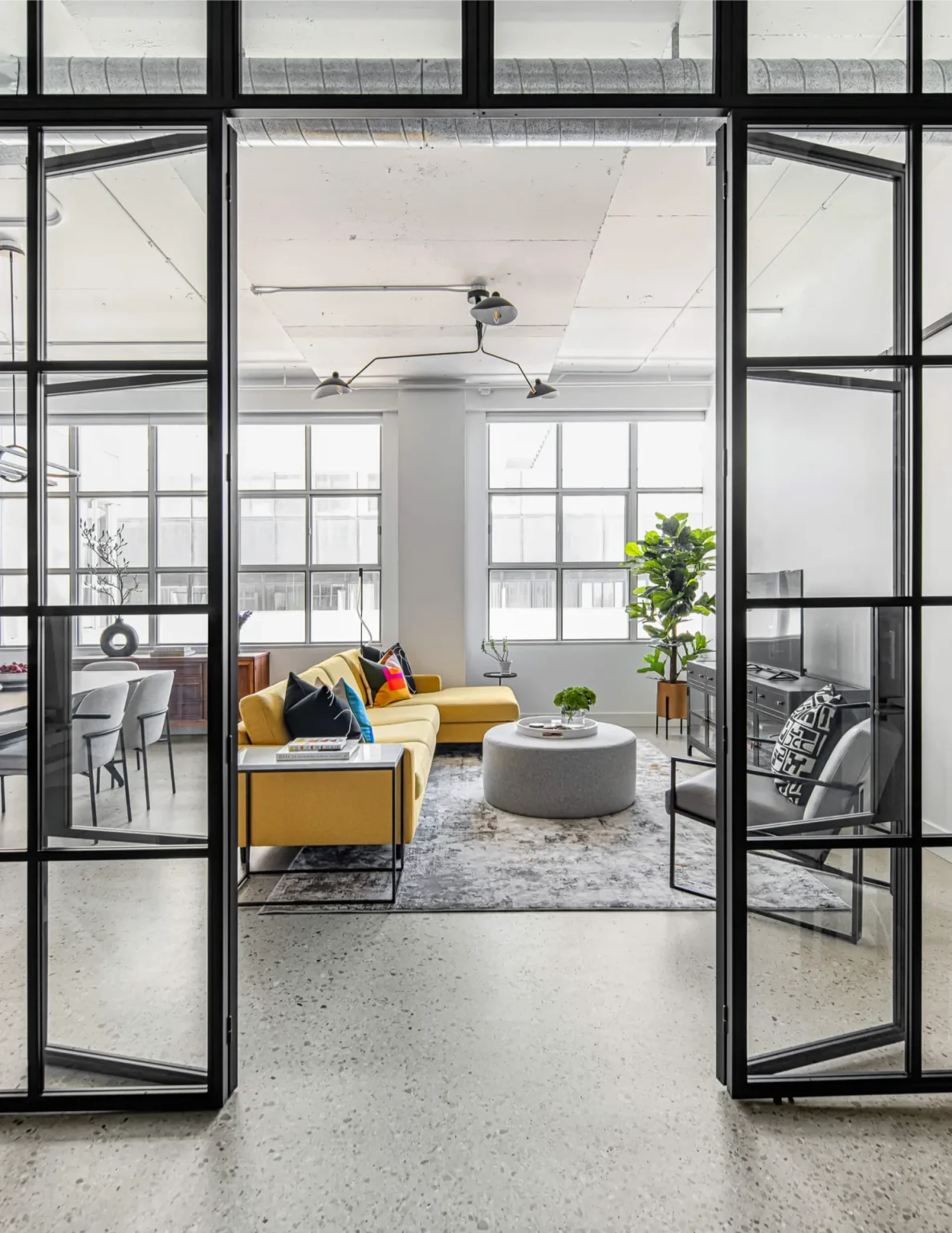 Glass and metal doors separating living room from library