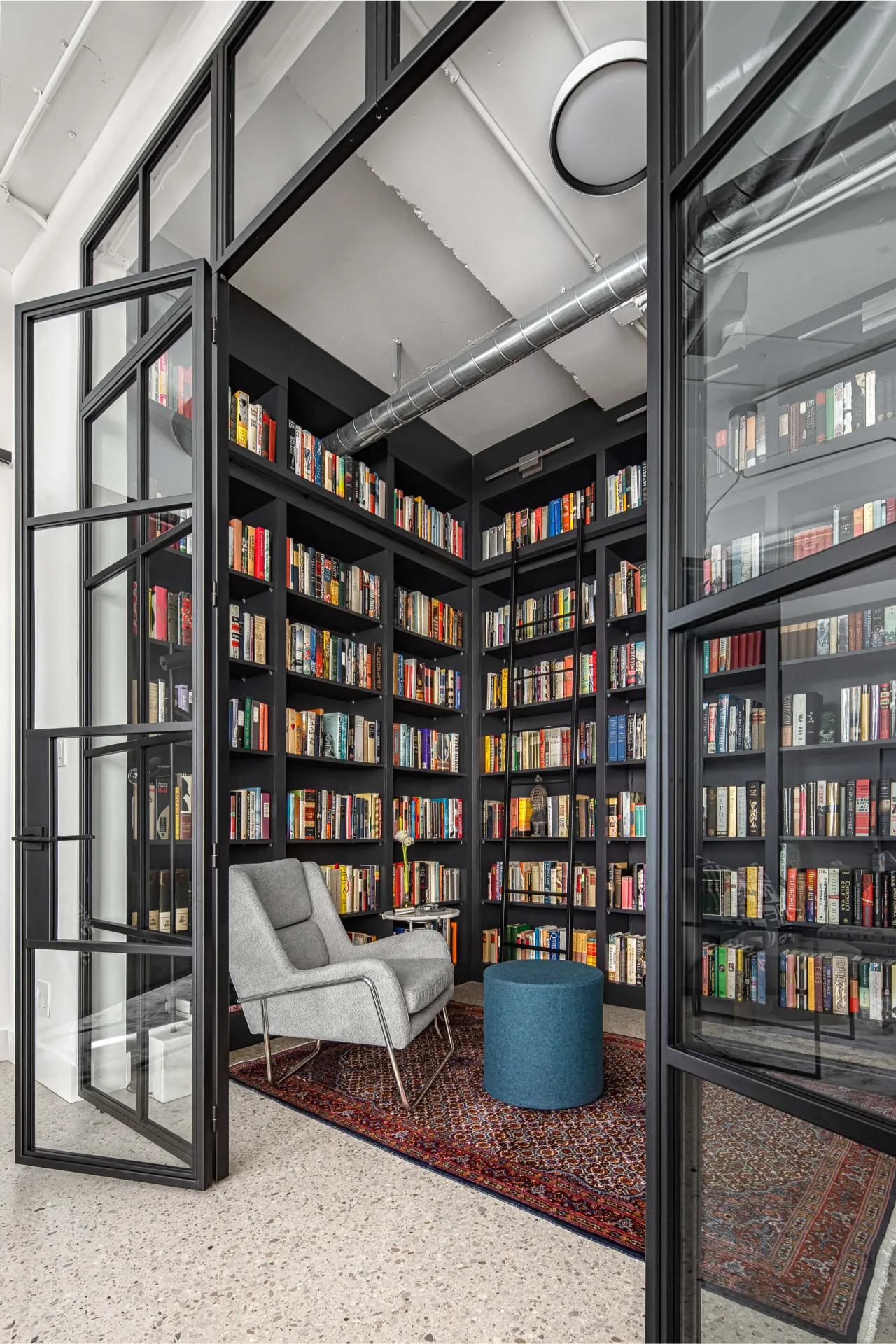 Rolling ladder detail in home library with built in shelving