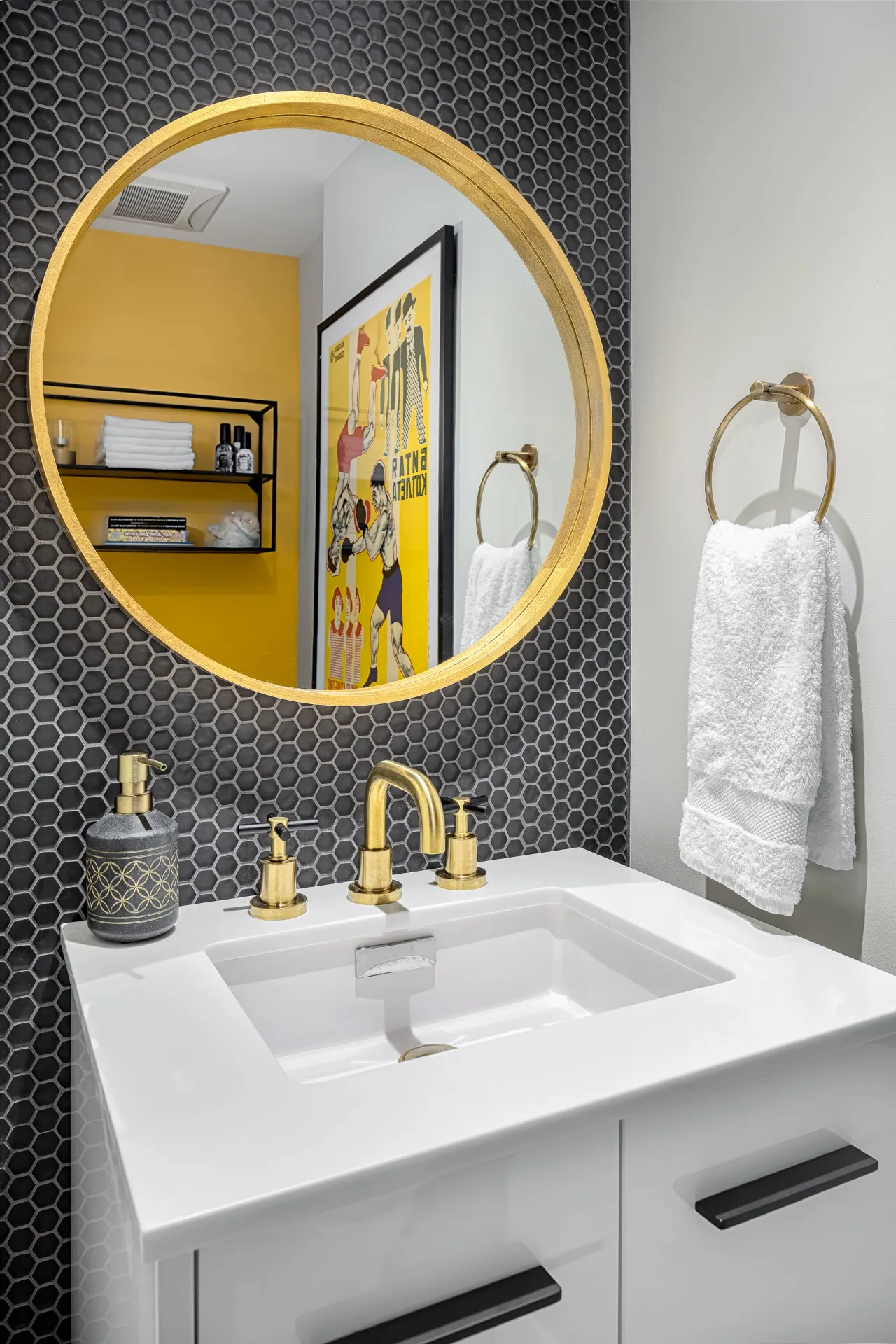 Bathroom vanity with black hexagonal tiles, gold hardware, and a bright yellow accent wall