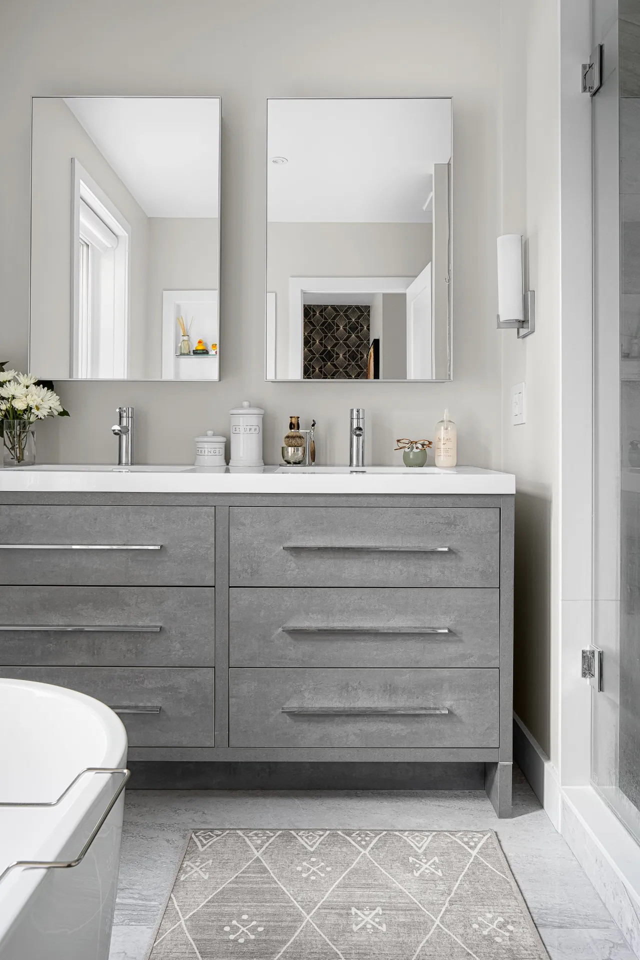 Bathroom featuring a grey concrete-look double vanity with silver hardware