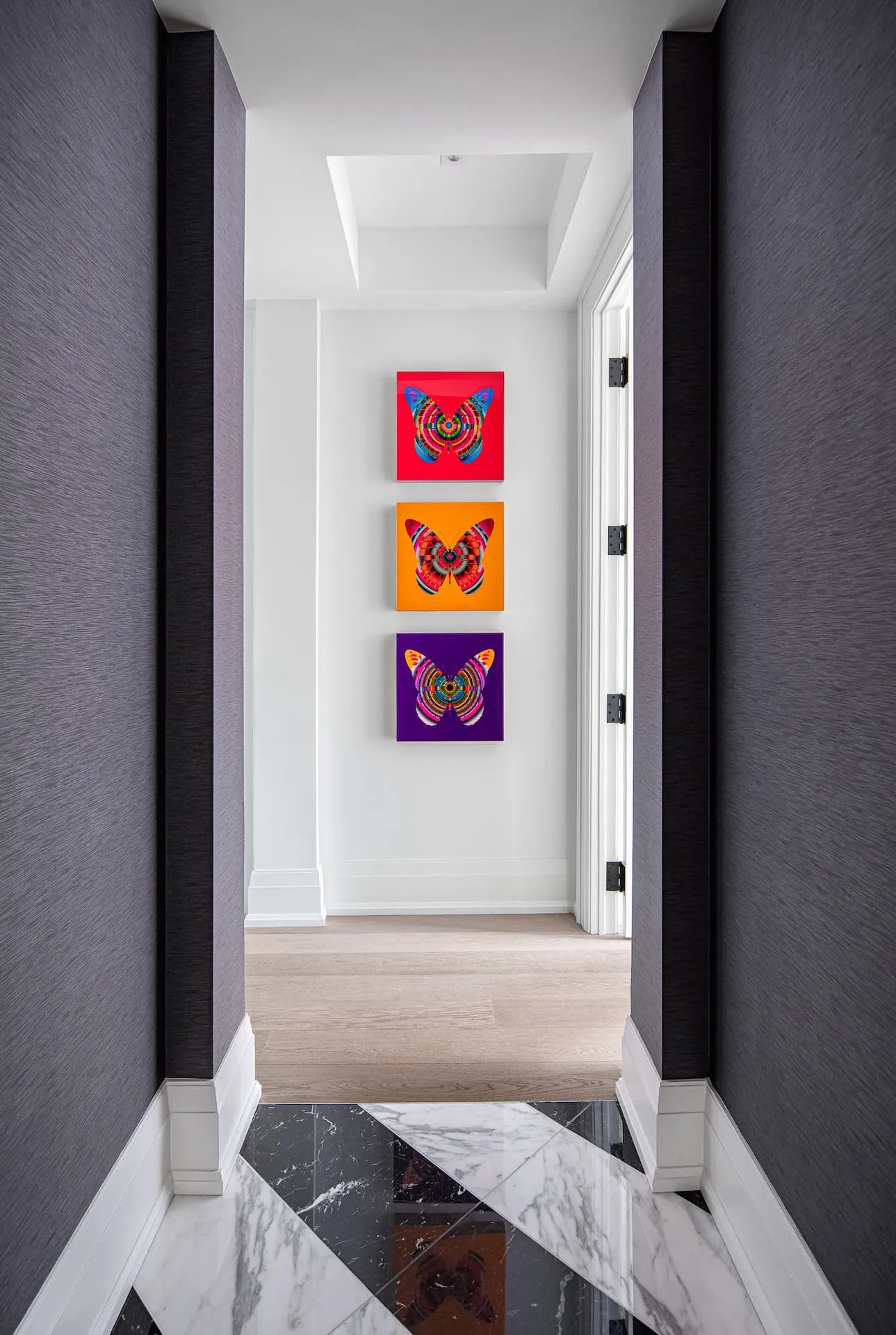 Three butterfly pieces by Canadian artist Franco DeFrancesca at the end of a hall