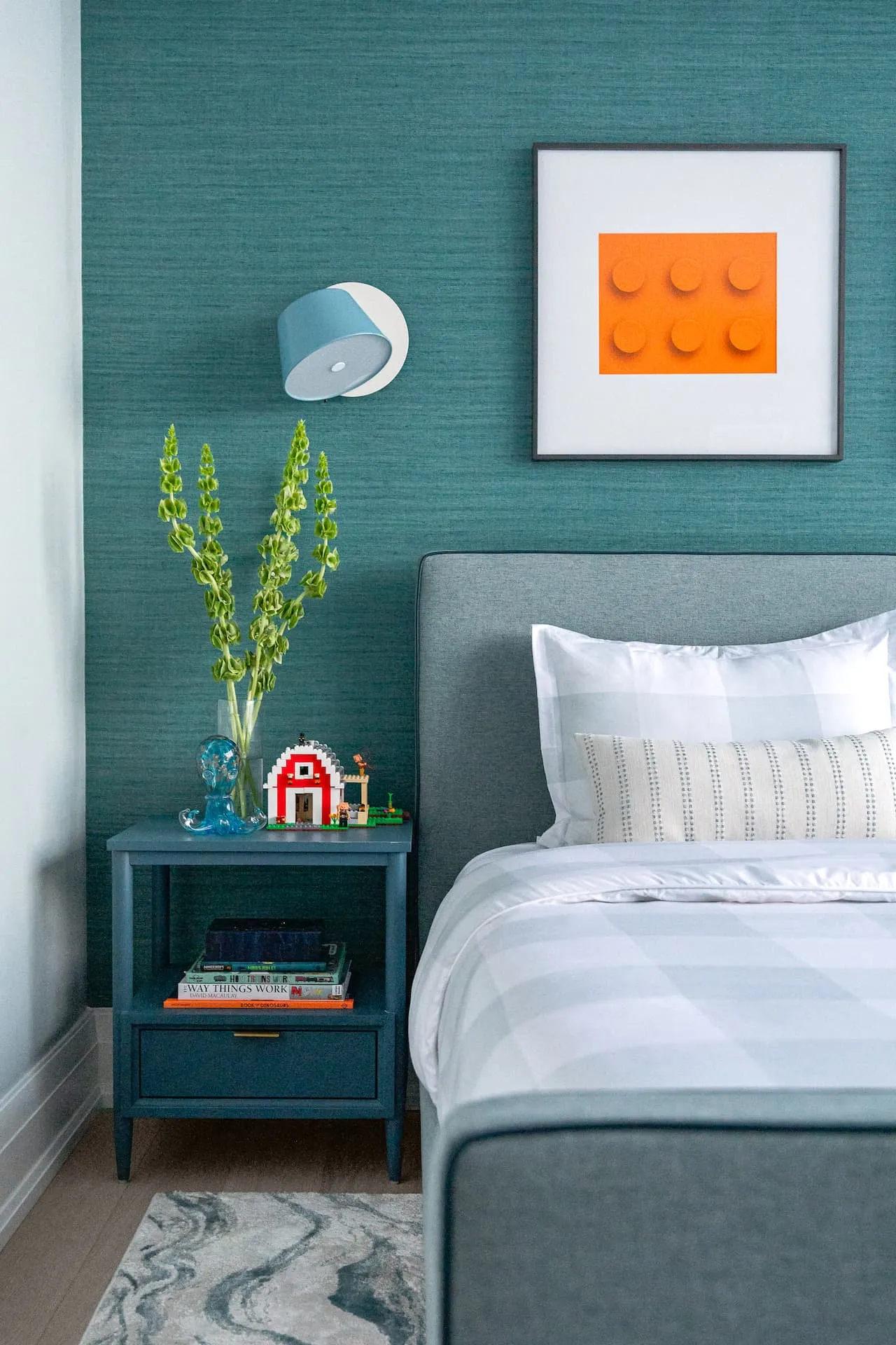 Subtle nods to dinosaurs and lego in a monochromatic blue boys room