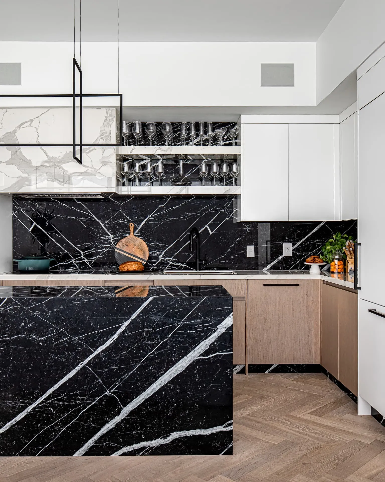 Kitchen featuring a large black marble island and backsplash with beautiful veining