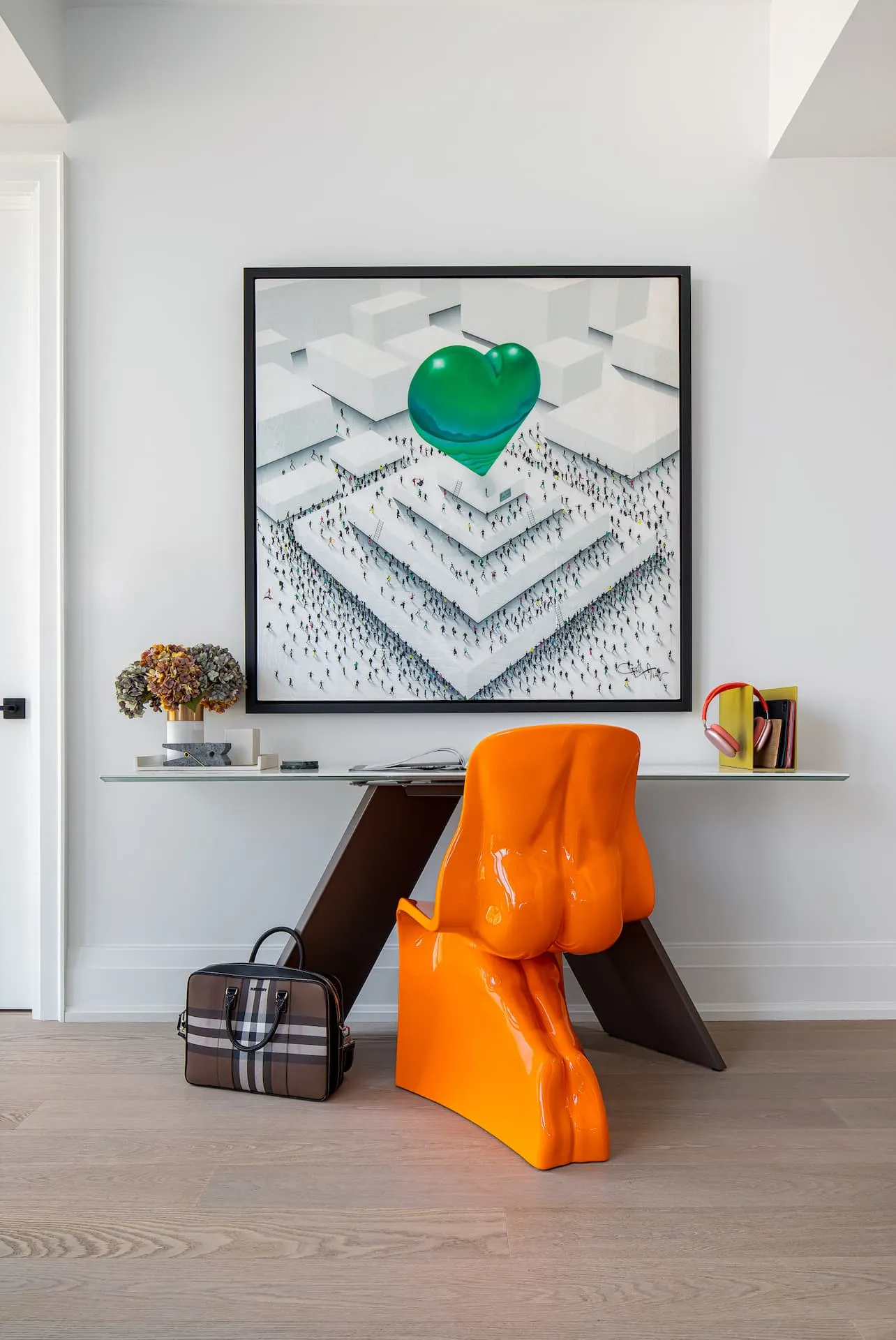 Yorkville Condo Design Primary Bedroom: Modern office nook in a Yorkville primary suite featuring a porcelain top desk, an orange Her chair, and Craig Alan artwork.