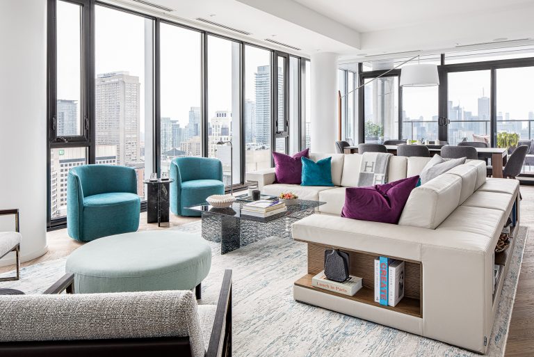 Cumberland Residence Yorkville luxury living room with floor-to-ceiling windows, panoramic Toronto skyline, low-profile cream sectional, and teal swivel chairs by Level Studio