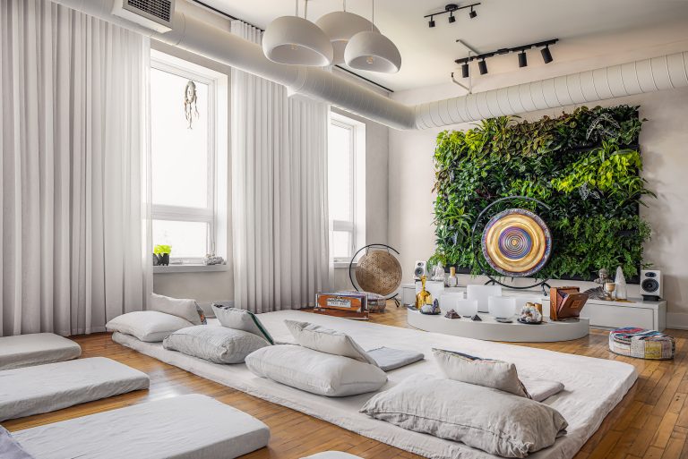 Stockyard loft Toronto Japandi industrial wellness studio with a 7x8-foot living green plant wall, floor meditation mats, gong and sound instruments, and floor-to-ceiling sheers in a former leather factory by Level Studio